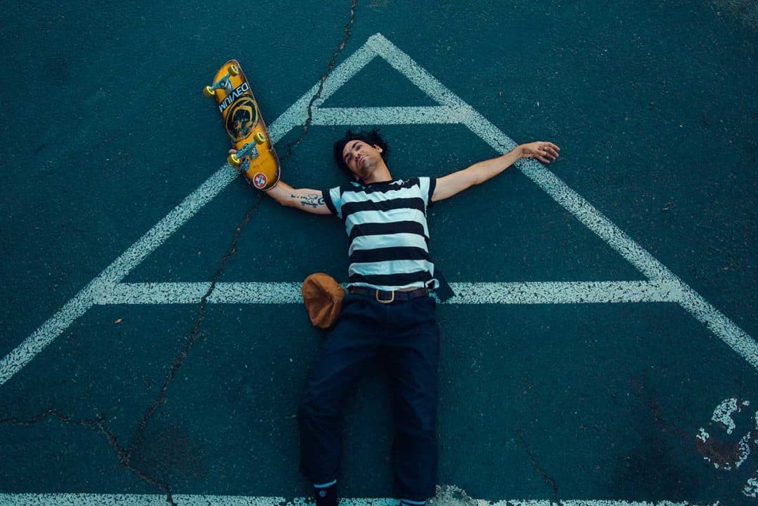 Skateboarder Corey Duffel on the ground with his board.