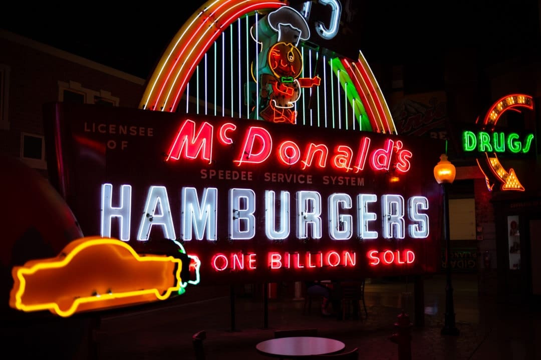 A large, neon McDonald's sign featuring the pre-Ronald mascot, Speedee
