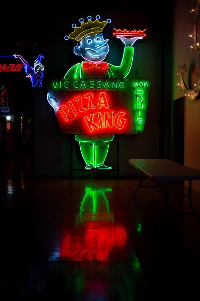 Cassano's pizza king sign features a man holding a pizza