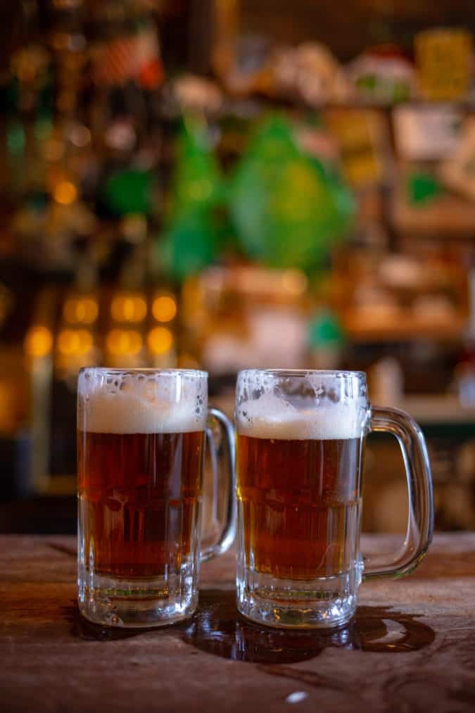 Two glasses of foamy light ale