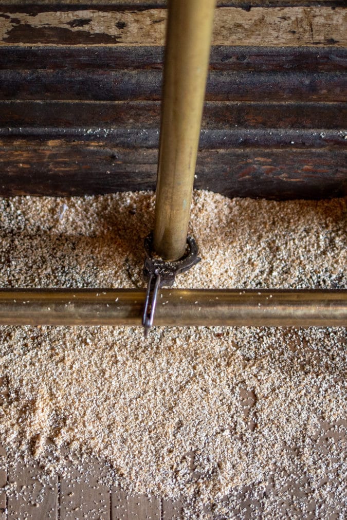 A set of handcuffs is cuffed to the bottom rail of the bar