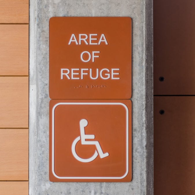 An accessibility sign that includes braille.