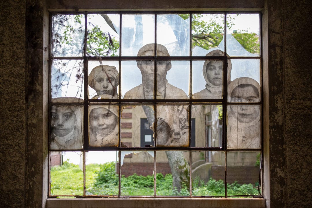 photos of children pasted on an old broken window