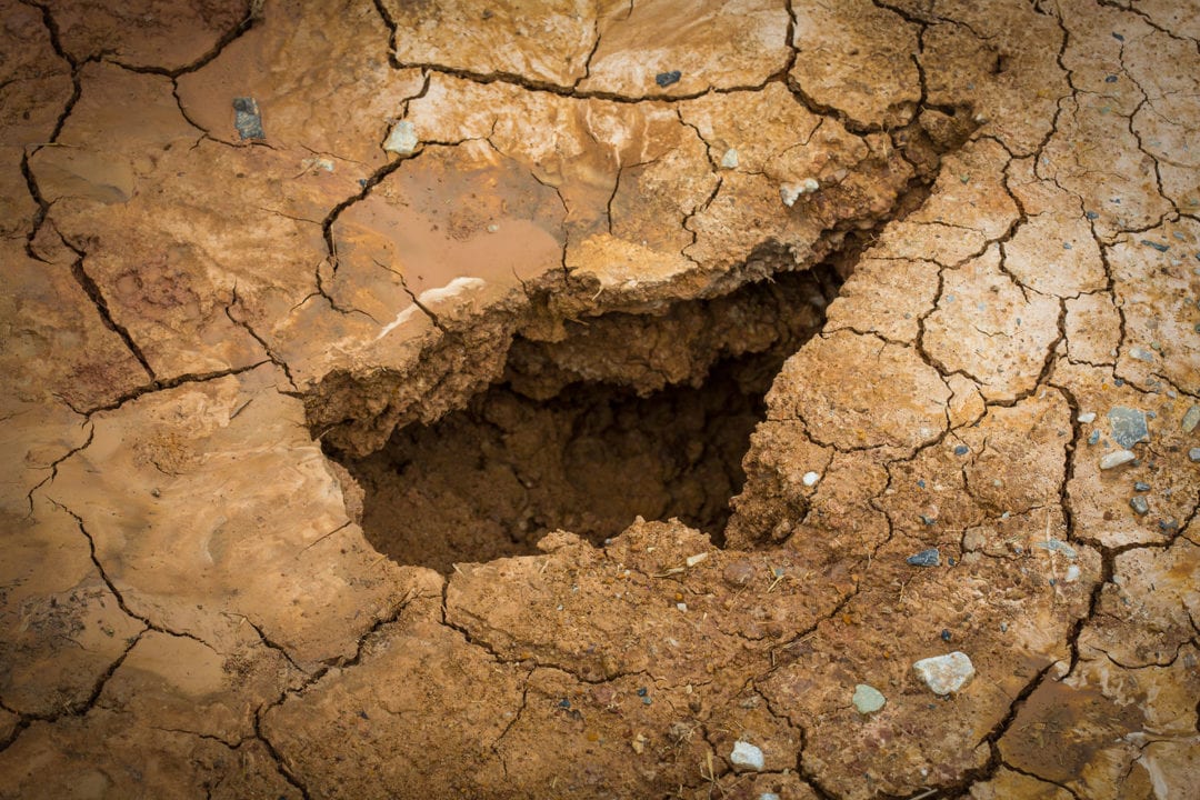 a hole in cracked dirt