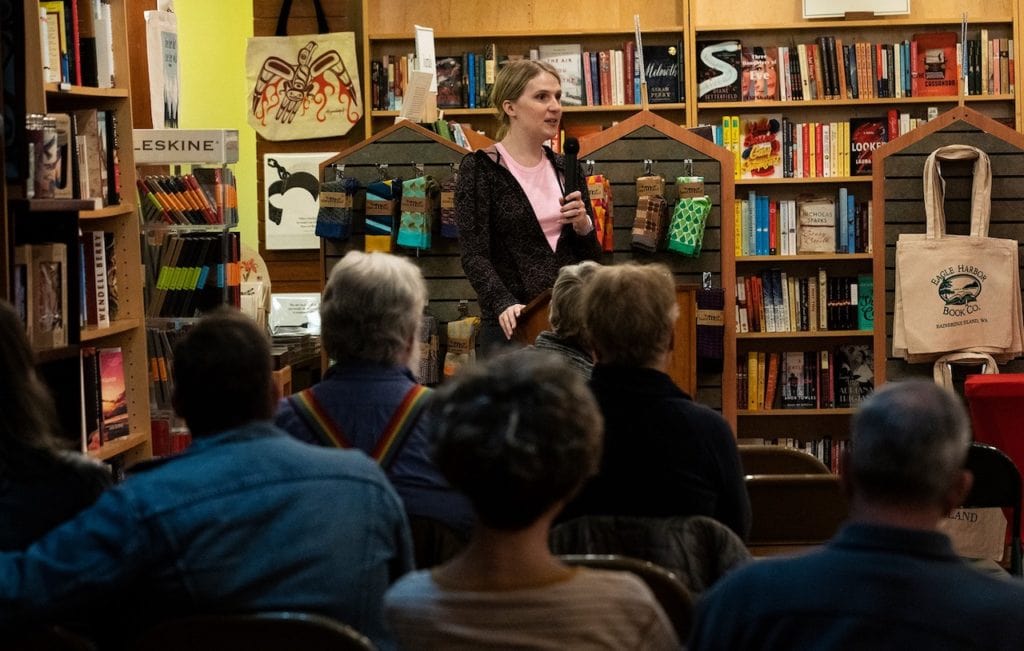 Samantha Allen stands in a crowded bookstore, speaking to a listening audience.