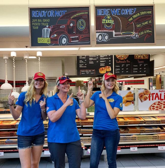 the team poses in a pizza place in front of a sign made just for them