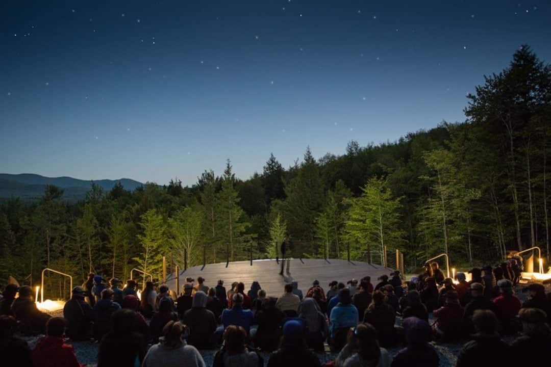 the ObservÉtoiles stadium backs up to a stage and a dark forest