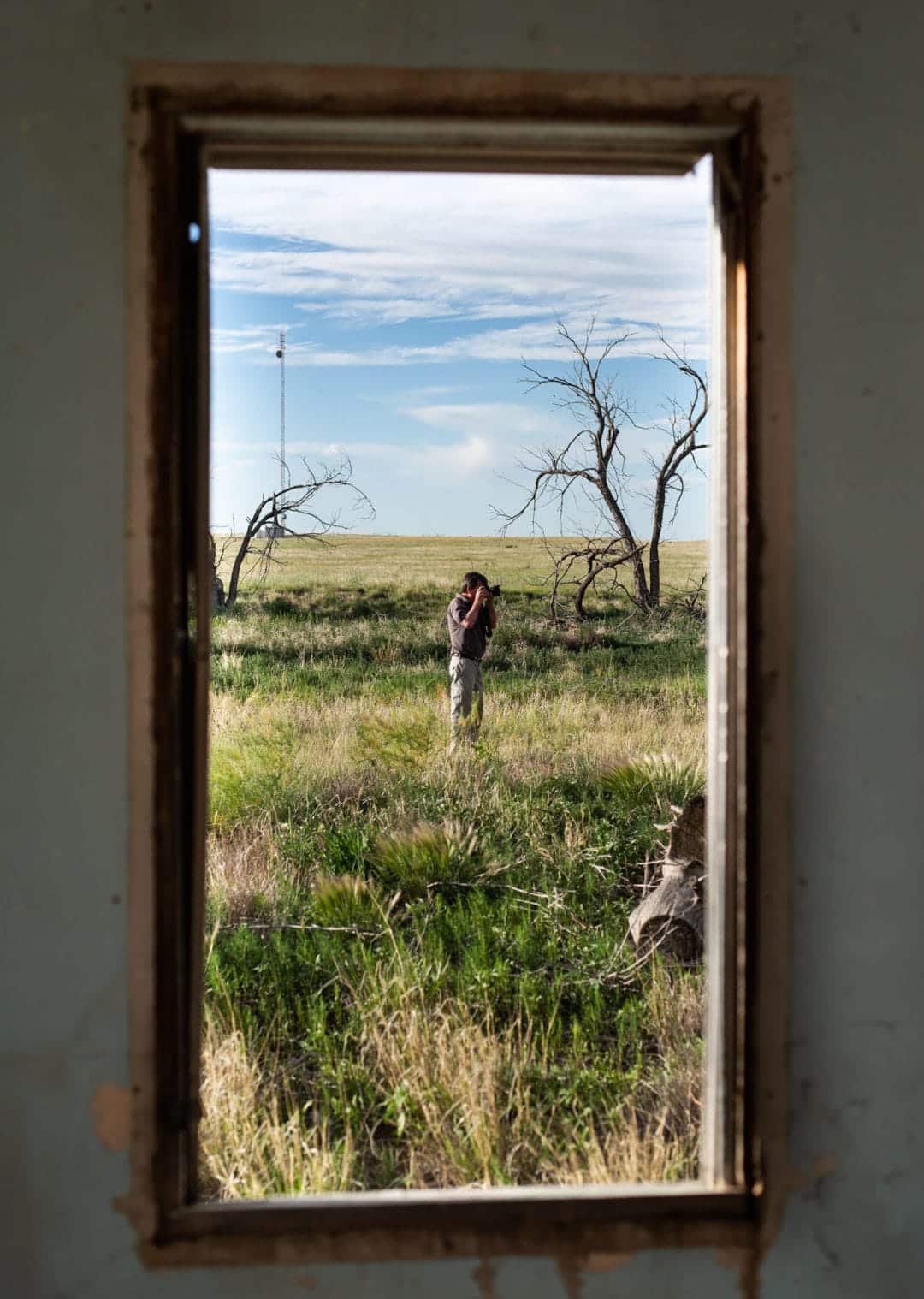 a man takes photographs of the sky in the middle of a grassy field