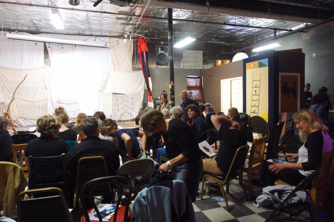audience members get ready to watch a show in mismatched seats