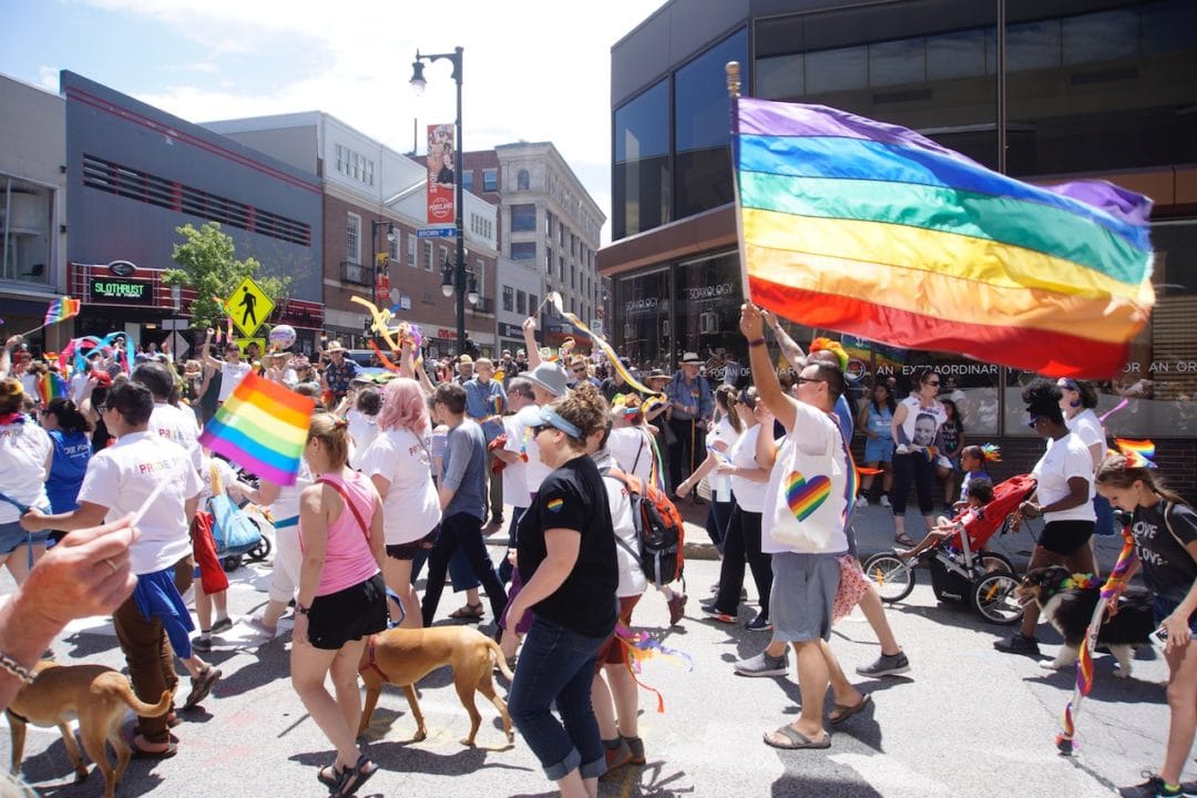 people march in a pride parade in downtown portland, maine