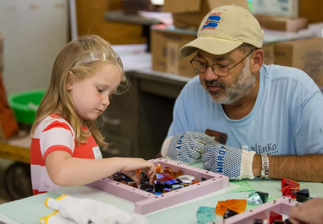 Jim Beck, right, helps 6-year-old Stephanie Dufore create a glass mosaic during the annual Festival of Glass.