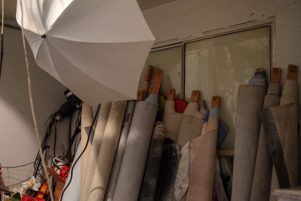 Rolled-up photo backdrops line the back studio wall.