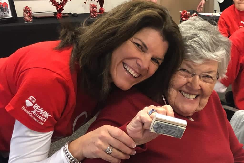 Volunteers pose for a photo while stamping valentines.