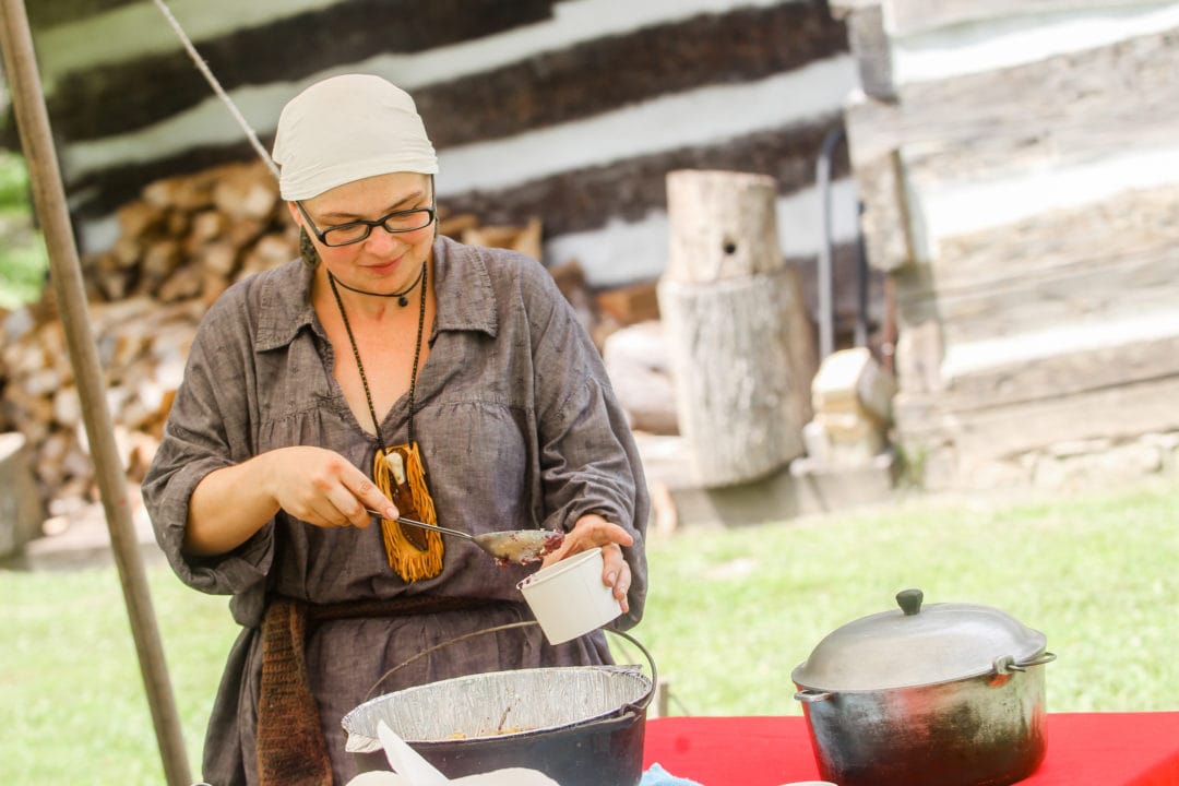 Whitney Roberts serves up cobbler from a cast iron Dutch oven at Heritage Farm’s Summer Ice Cream Festival.
