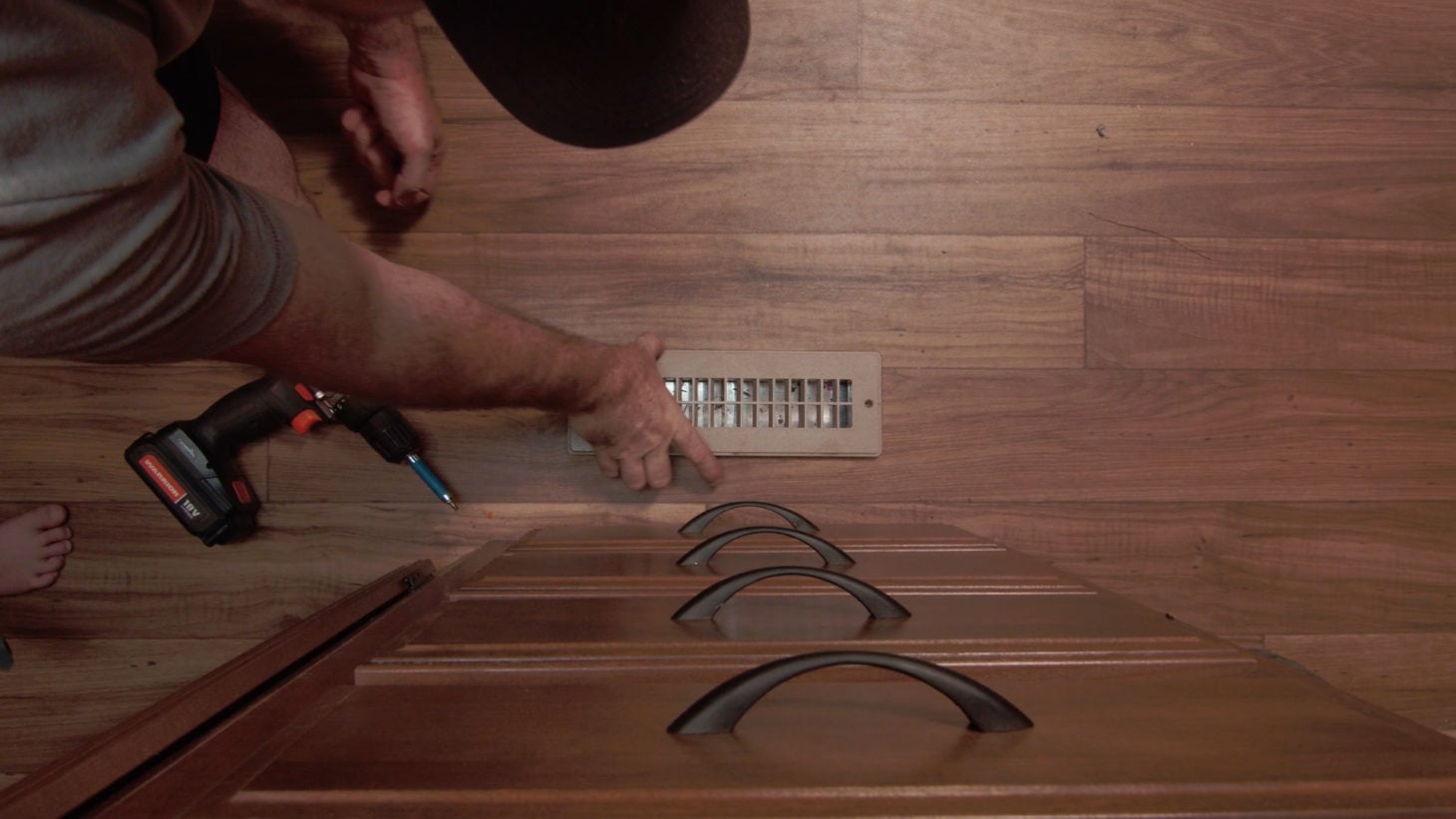 Man unscrewing air vent in an RV to clean