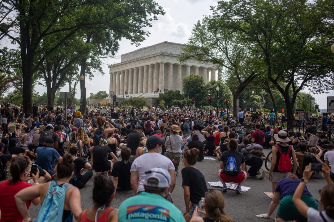 The crowd takes a knee to listen to speeches near the Lincoln Memorial.