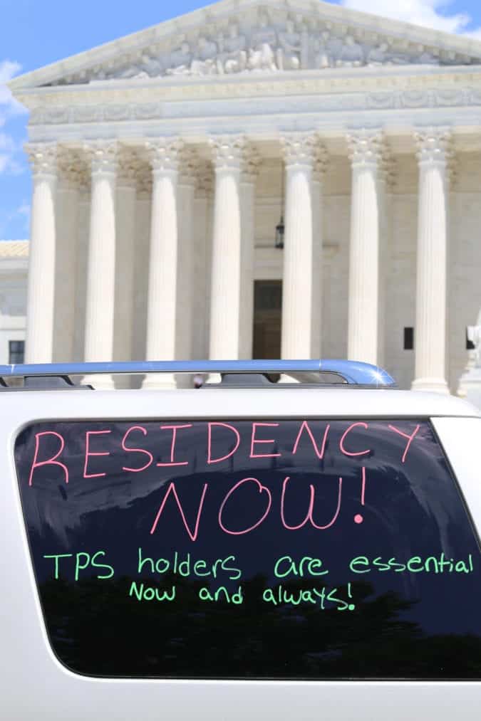 Car window painted with the words "Residency Now!"
