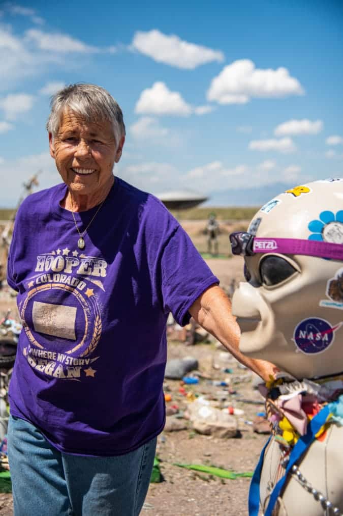 Judy Messoline wearing a purple shirt and standing in her garden.