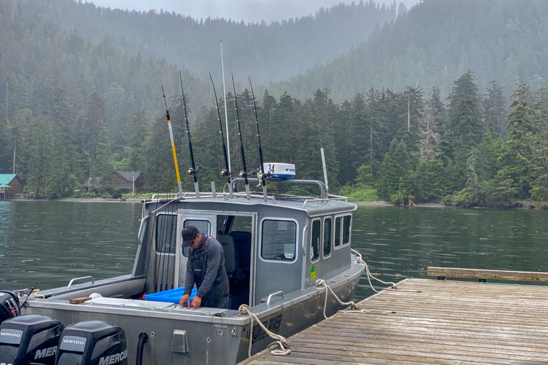 Man standing onboard an aluminum fishing boat