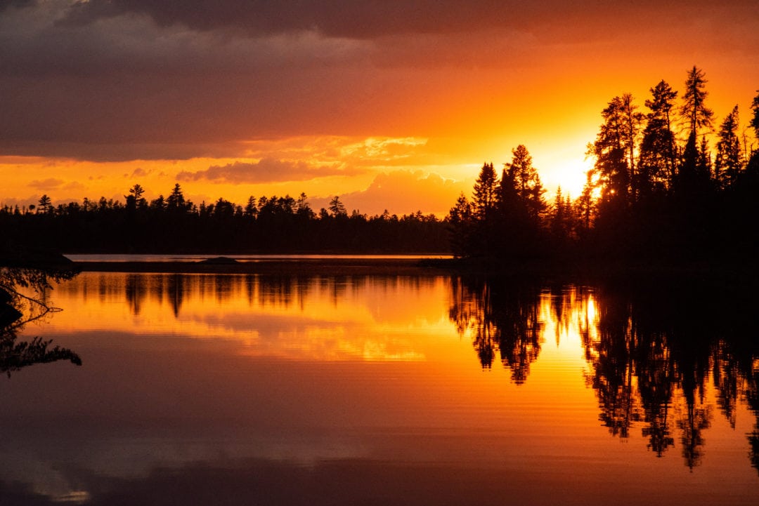 Mother Nature illuminates the sky with magnificent fiery pigments over Disappoint Lake’s tree-silhouetted landscape. “They might have gotten this lake’s name wrong,” Peter jokes.