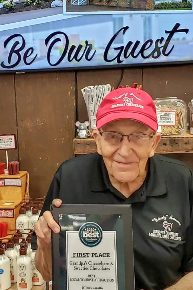 Dick Baum holds an award for "Best Local Tourist Attraction." 
