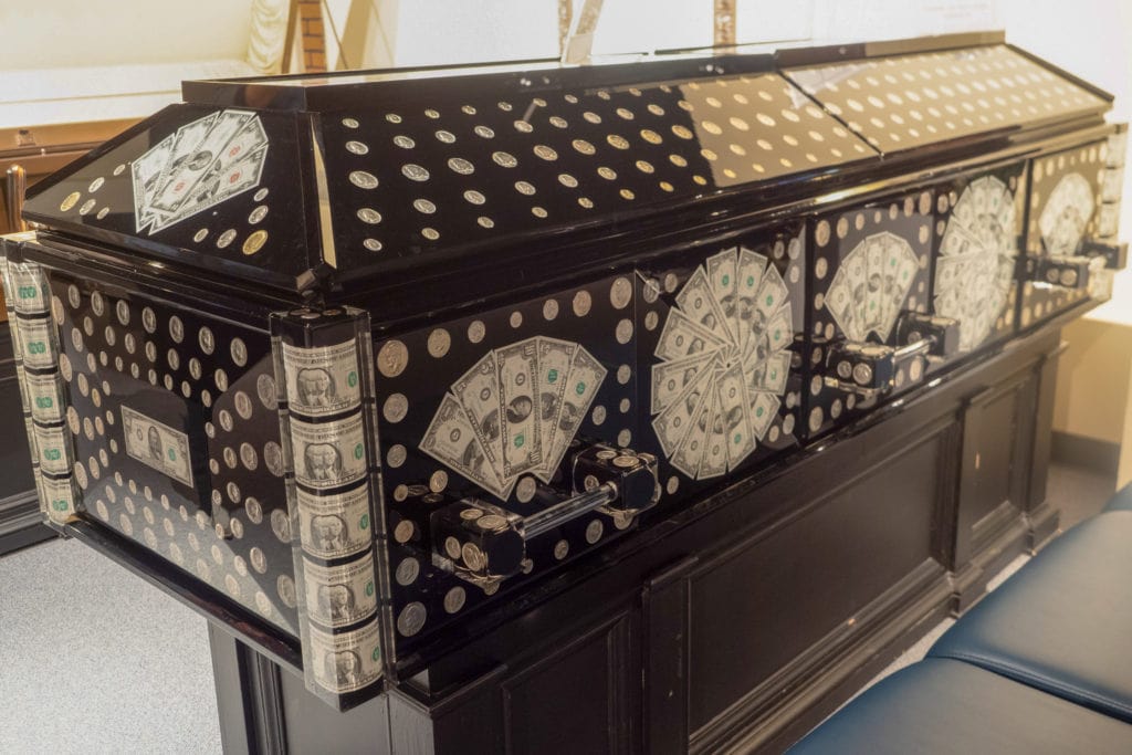 A coffin covered with money.