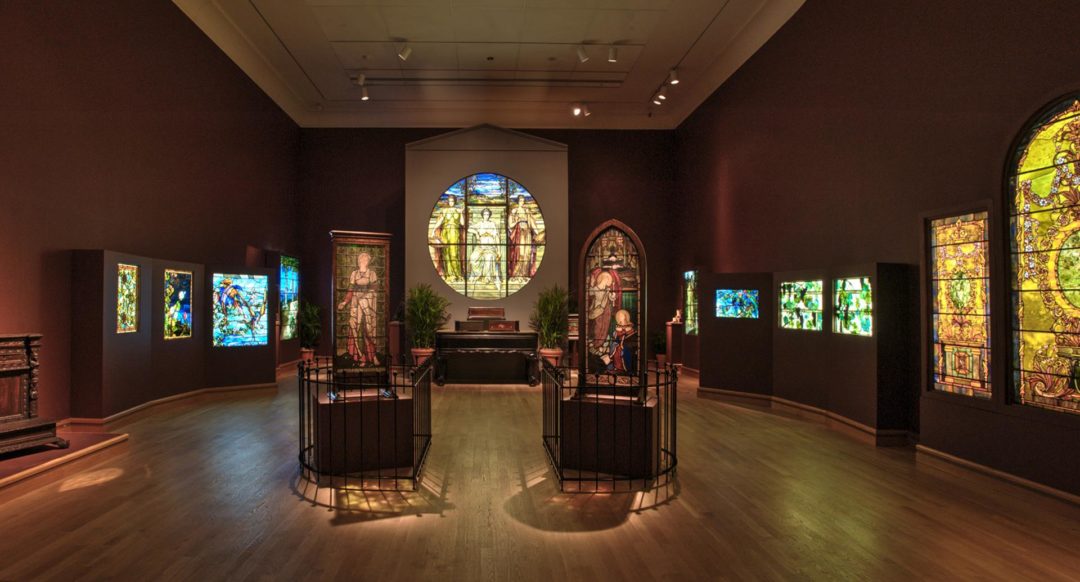 Dark interior of a room with stained glass art pieces on the wall