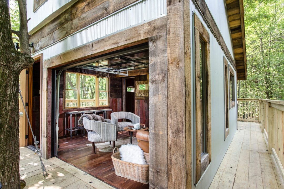 A rustic treehouse with wood floors and a dining area