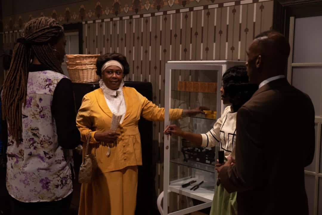 three black women and one black man are dressed in period costumes