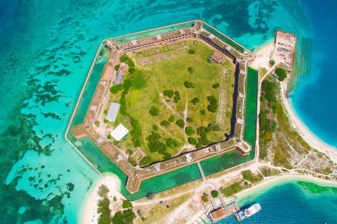 an aerial shot of a fort in the middle of blue water in florida