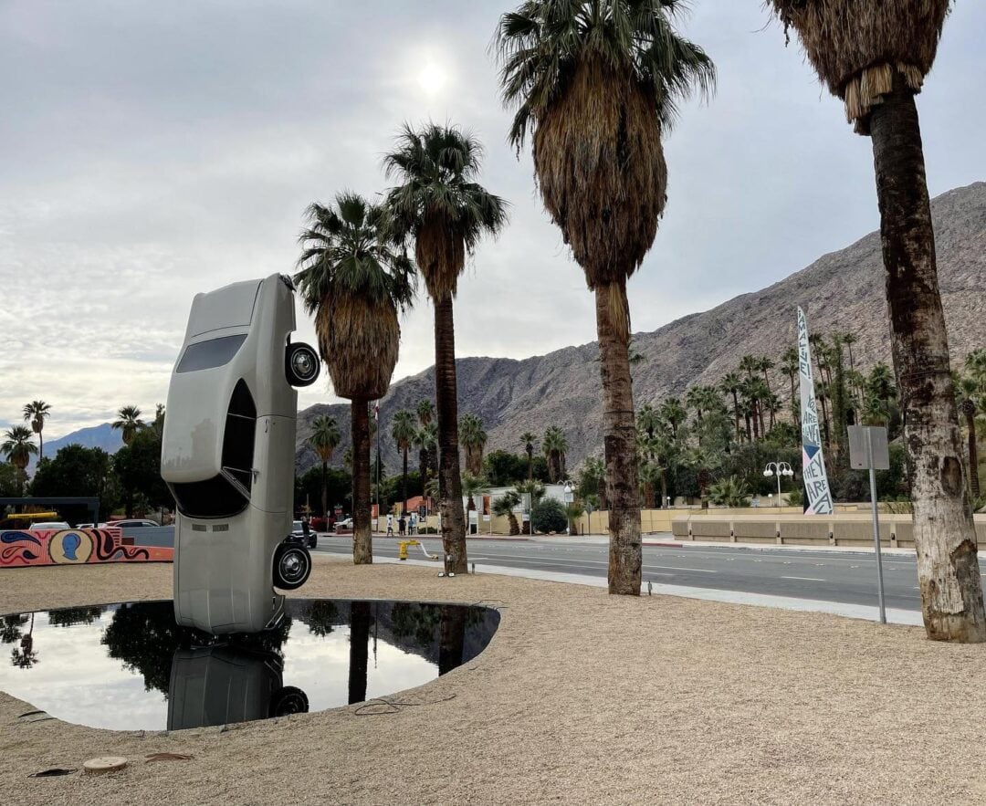 Outdoor exhibit of an upside down car at the Palm Springs Art Museum