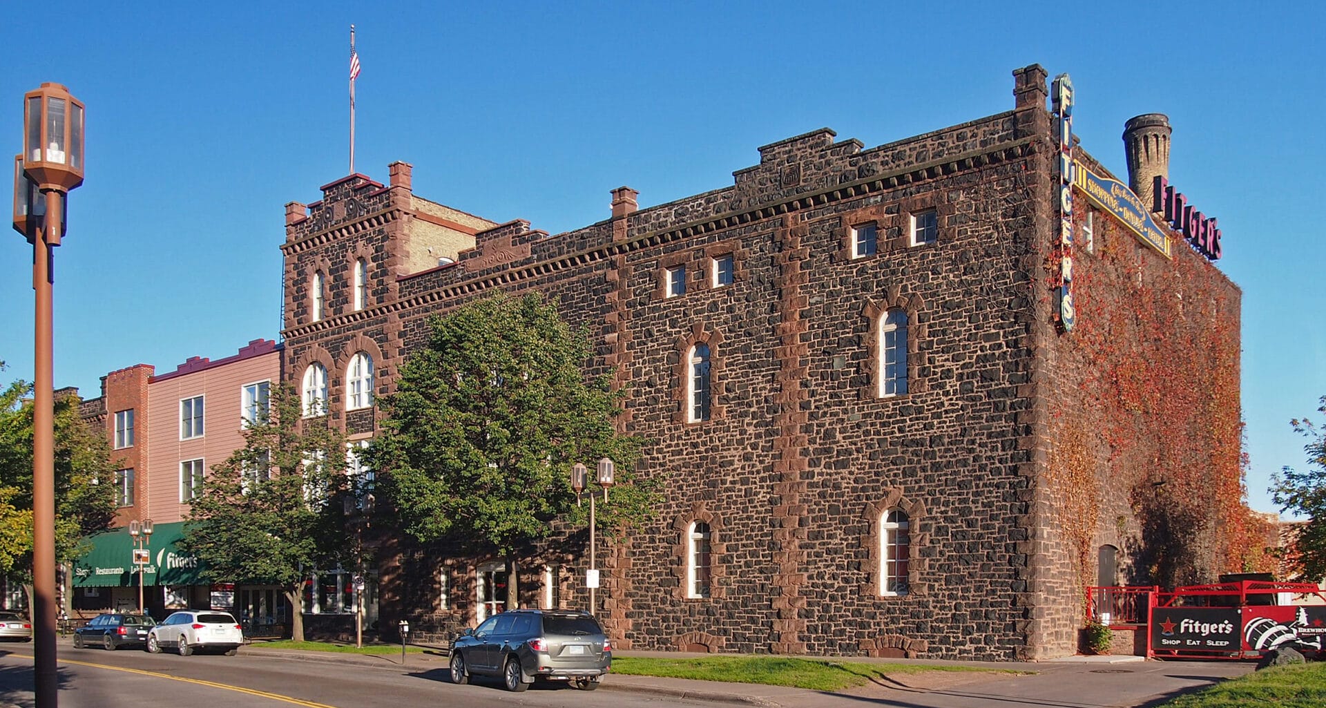 a castle-like red brick building against a blue sky, fitger's brewhouse