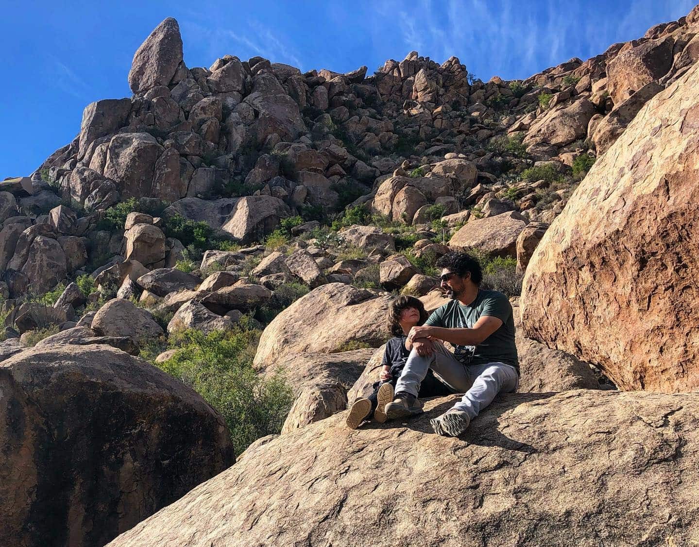 Father and son sitting on a rock formation at Big Bend National Park