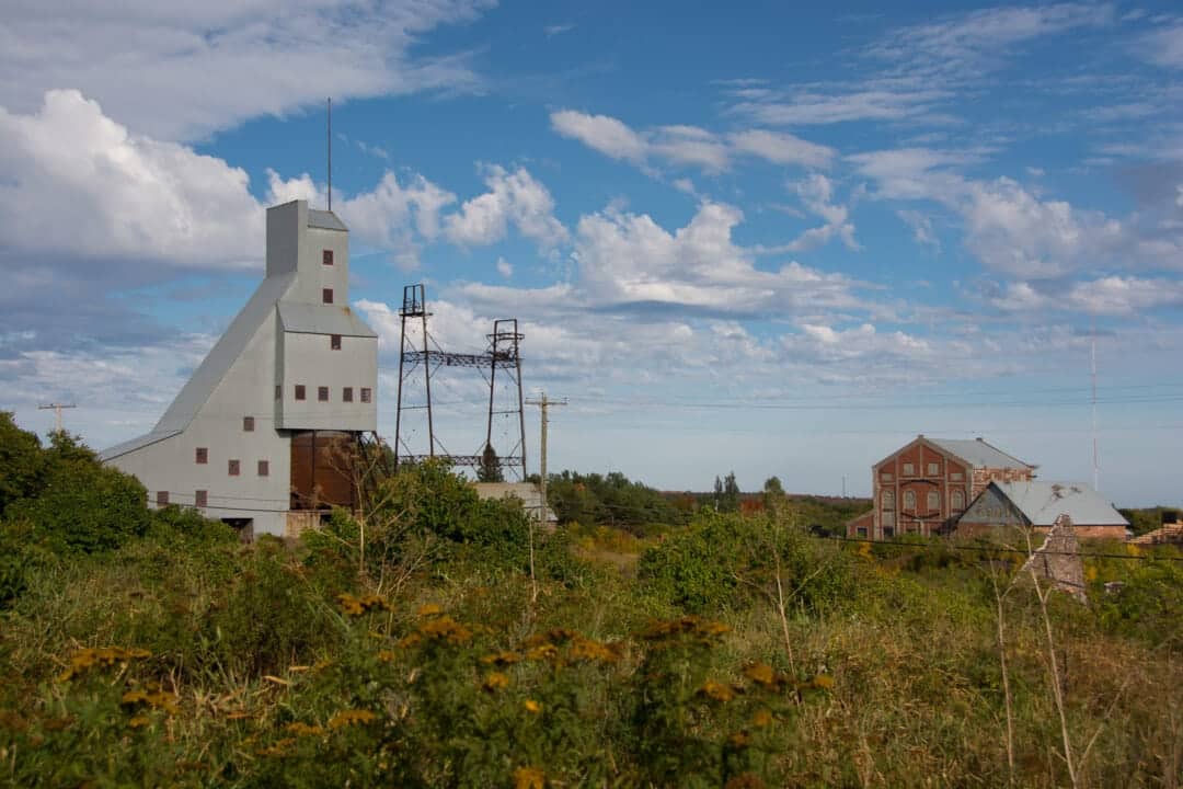 old mining structures surrounded by greenery and a blue sky keweenaw peninsula