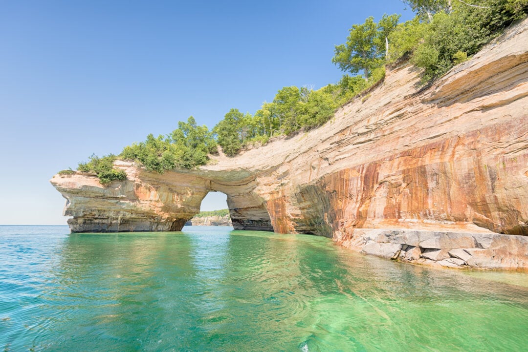 a green blue lakeshore with a red rock pictured rocks national lakeshore