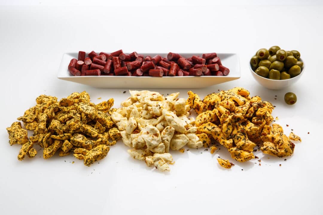 cheese curds, sausages and olives on a white background