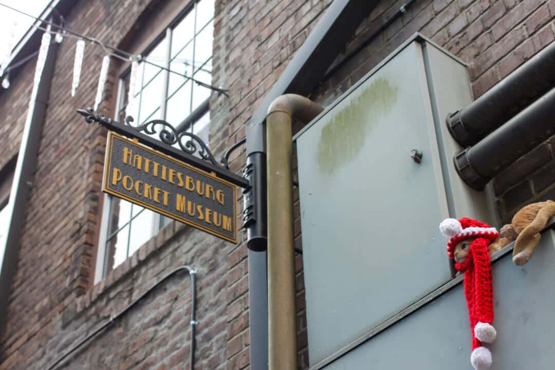 a sign hangs off a brick building that says "hattiesburg pocket museum"