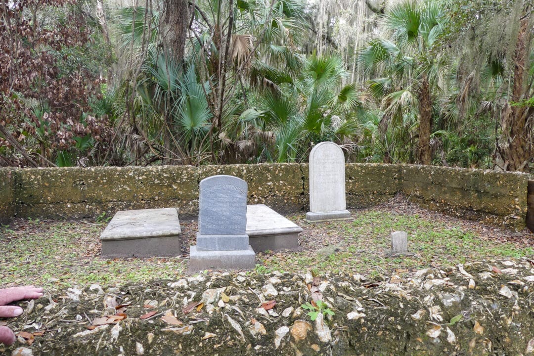 a small cemetery with several headstones surrounded by greenery