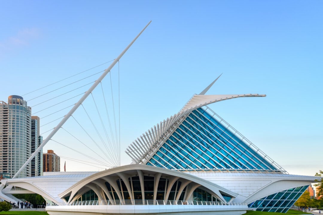 a modern white art museum with large retractable wings against a blue sky