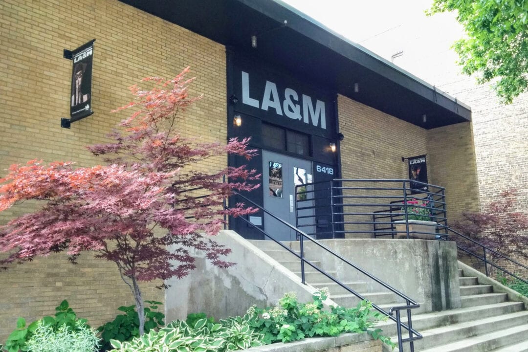 the entrance to a brick building with a flowering tree out front