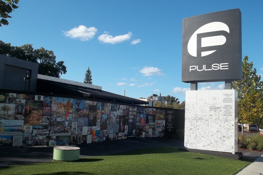 a black and white sign that says pulse next to a wall of photos