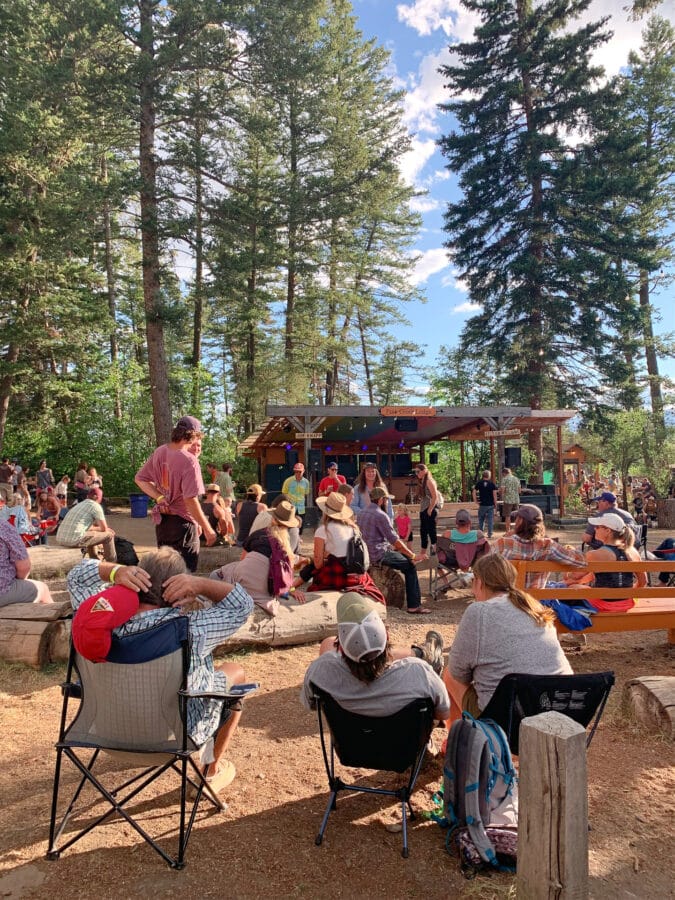 Small crowd at a campground with stage and performers