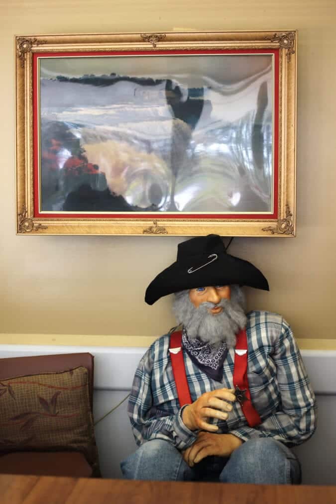 a mannequin of a miner sits beneath a portrait of niagara falls