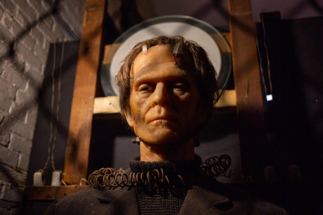 a wax frankenstein figure behind a chainlink fence