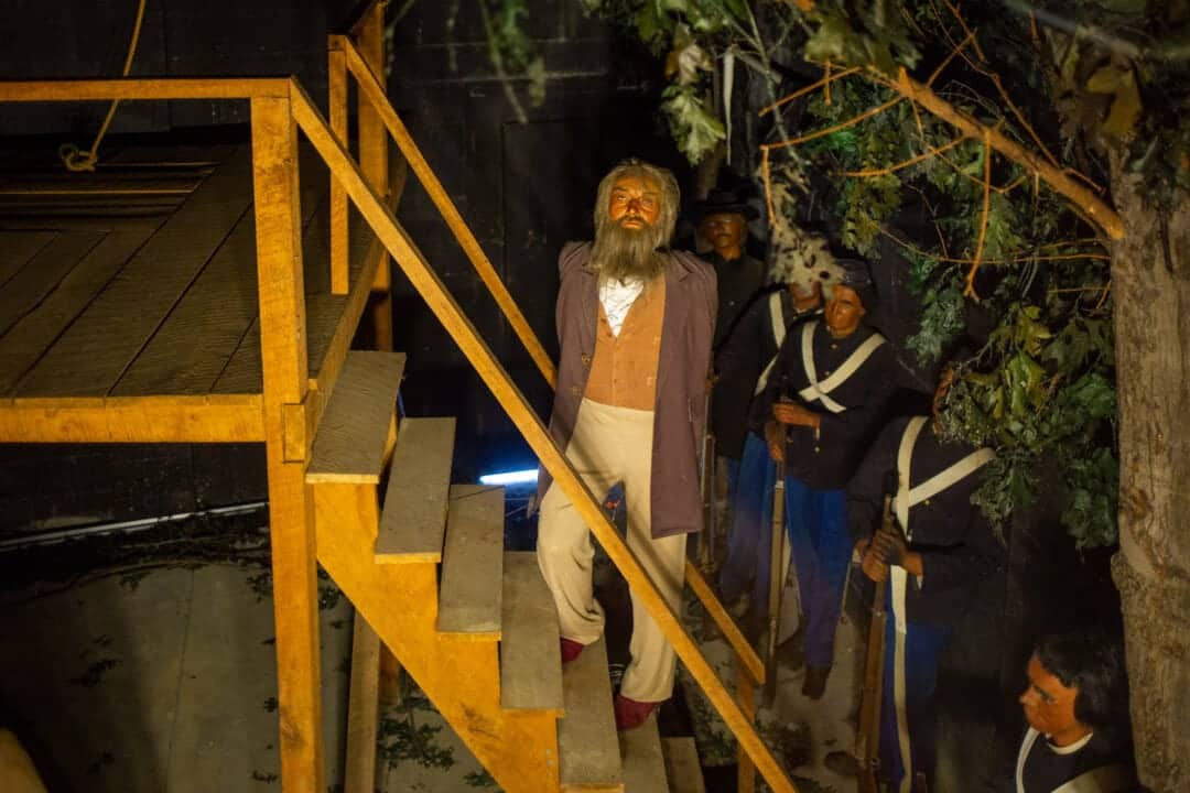a wax figure of john brown standing on a wooden gallows