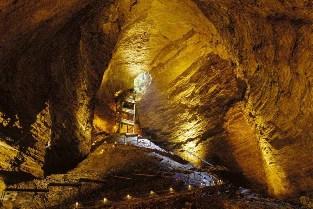 a cave lit up with illuminated wooden walkways
