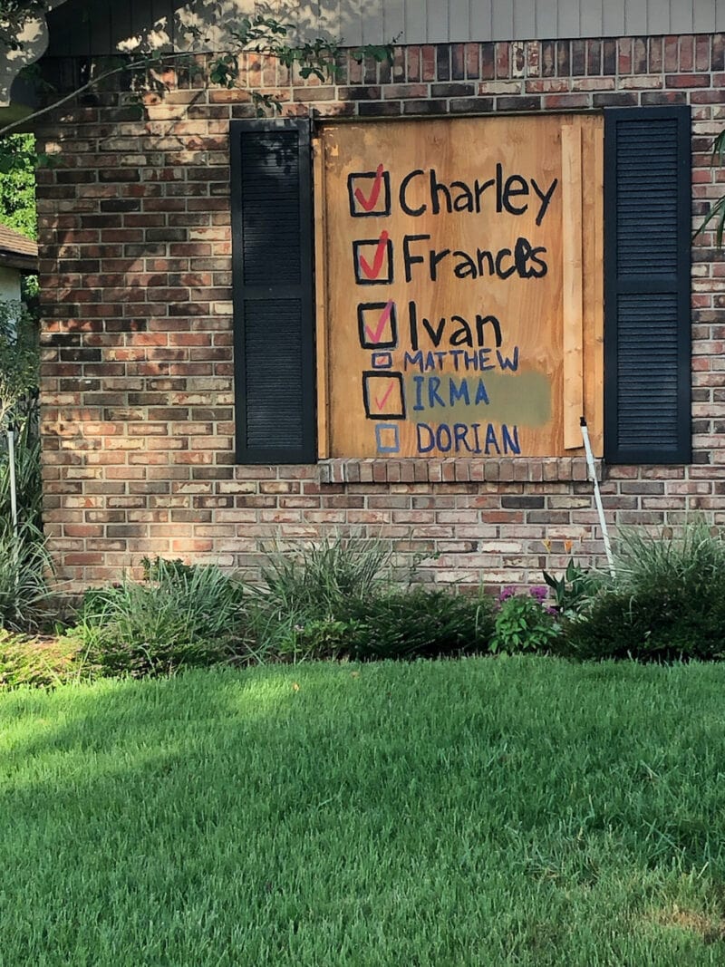 Boarded up window with list of hurricane names