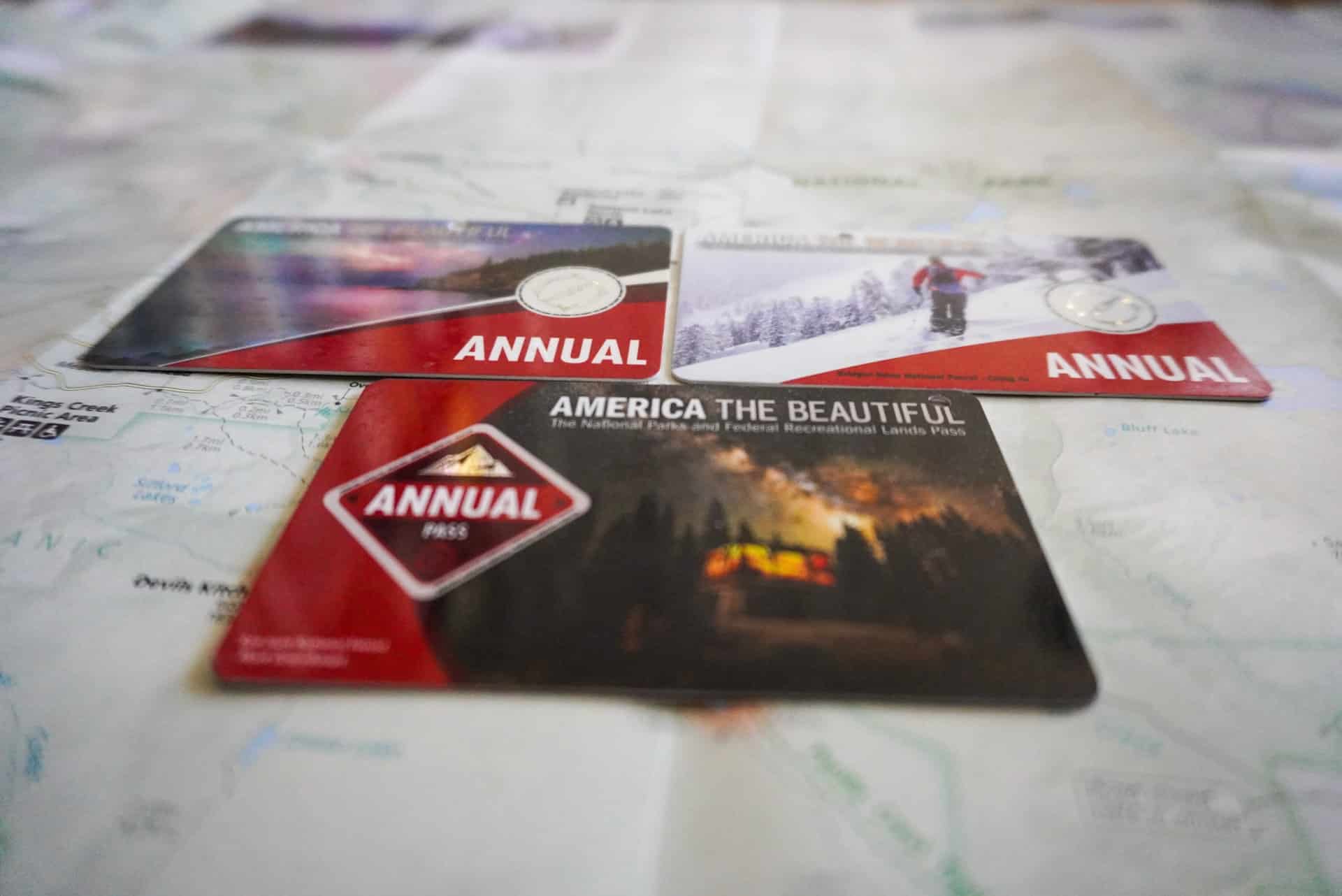 Three America the Beautiful passes on top of a map