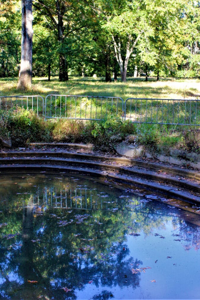 a pool of standing water outside surrounded by a metal barricade
