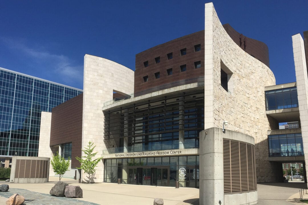 A modern-looking building features large glass windows and soaring architectural details.